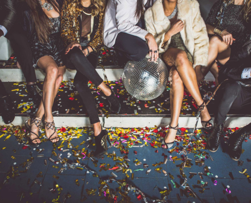 Partygruppe einer Bachelor Party sitzt auf einer Treppe mit Konfetti