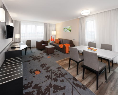 Geräumiges Superior-Zimmer im SI-SUITES Hotel Stuttgart mit Wohnzimmer, TV und Essbereich