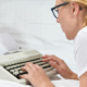Frau mit Schreibmaschine im Bett