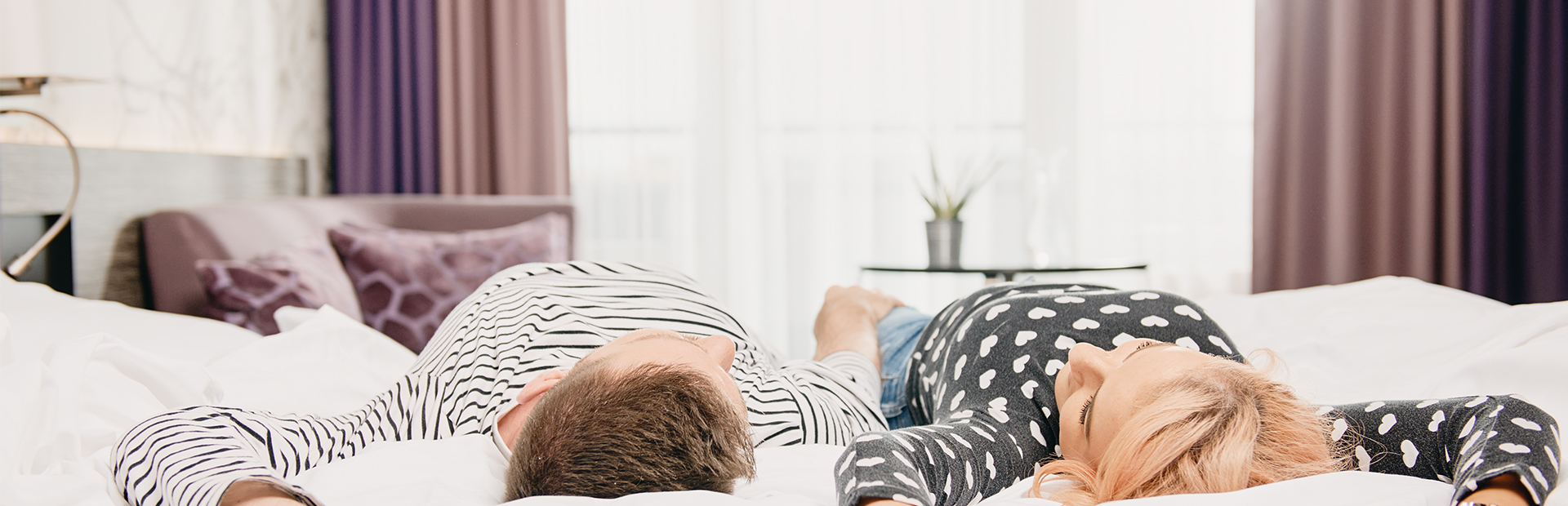 Mann und Frau liegen zusammen auf einem Bett in den SI-SUITES in Stuttgart