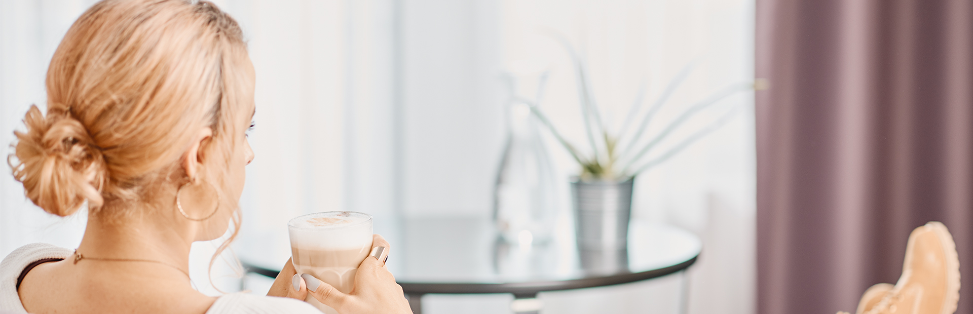 Frau genießt einen Latte machattio in einer Junior Suite